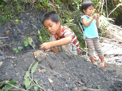 Trẻ em thôn 3 Tiên An chơi đùa bên vùng đất đen. Ảnh: N.T