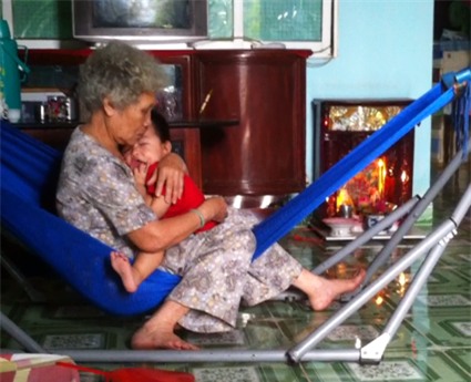 Cháu Khôi được bà ngoại chăm sóc khi đang lên cơn động kinh