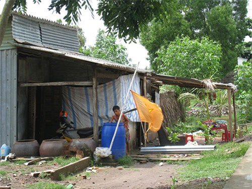 Một hộ dân ở tỉnh Cà Mau hứng nước mưa từ tấm lợp có chất amiăng 
Ảnh: DUY NHÂN