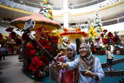 6. Malaysia: phụ nữ Hồi giáo chụp ảnh tự sướng trong một Trung tâm mua sắm tràn ngập không khí Giáng sinh, Kuala Lumpur ngày 4/12 (Ảnh: AP)