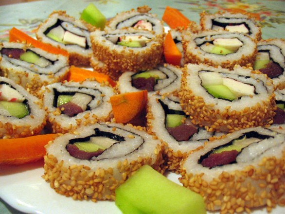 Để có món sushi vừng rang, bạn gỡ bỏ lớp lá kim bọc bên ngoài miếng sushi, lăn qua vừng rang, ăn sẽ bùi và ngậy hơn. 